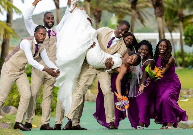 Bridal Team A groom, groomsmen, and bridesmaids all holding a bride