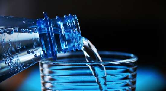 Purified bottled water being poured into a glass.
